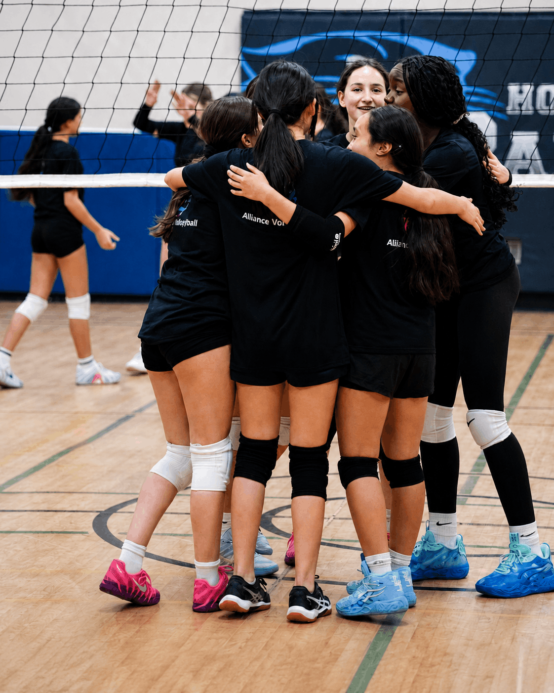 Alliance Volleyball athletes supporting each other during a team huddle
